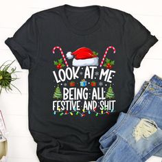 Ugly Christmas T Shirt, Look at Me Being All Festive and Shits Funny Christmas Santa Tshirt, Christmas Tshirt Designs The T-Shirt, a timeless wardrobe staple, combines comfort with effortless style. Crafted from soft, breathable fabrics, it ensures a cozy fit for everyday wear. Its versatility makes it a go-to choice for various occasions, from casual outings to laid-back evenings. With a range of colors and designs, T-Shirts cater to diverse tastes, allowing self-expression through fashion. The Festive Crew Neck T-shirt For New Year, Festive Christmas Crew Neck T-shirt, Christmas Crew Neck T-shirt With Letter Print, Crew Neck T-shirt For New Year's Holiday, Christmas Holiday T-shirt With Letter Print, Christmas Letter Print Crew Neck T-shirt, Crew Neck T-shirt For New Year Holiday, Funny Black Christmas T-shirt, Festive Crew Neck T-shirt With Letter Print