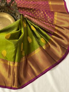 Shop for the most traditional Kanchipuram handloom silk saree in Olive green color making it look stunning and grandeur. The Kanchipuram Silk Saree enchants with gold zari motifs all over. The weave is beautifully complemented with a contrast gold zari  border. The contrast gold zari pallu with circles in series along with tassels and contrast blouse with zari border resonate with each other perfectly. This beautiful color combination saree is perfect for any occasion.  This saree is ready to wear with fall and pico done. Complimentary Fall, Edging and handmade silk tassels adorn the pallu and add more grace to it. An unstitched blouse fabric comes with the saree. Silkmark Certified  *Note: There may be minor variations in the color, the texture of the product. Color/textures show differen Green Handloom Tussar Silk Traditional Wear, Green Tussar Silk Traditional Wear, Green Handloom Saree For Puja, Traditional Green Handloom Saree, Green Zari Weaving Traditional Wear For Festivals, Green Tussar Silk Traditional Wear With Patterns, Green Tussar Silk Saree For Puja, Green Handloom Traditional Wear For Diwali, Green Traditional Wear With Self Design For Puja