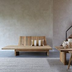 a wooden bench sitting next to a coffee table on top of a carpeted floor