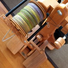 a wooden loom with spools of thread on it