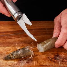 a person using a knife to cut up something on a cutting board with an object in the foreground