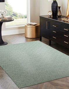 a living room area with a rug, side table and vases