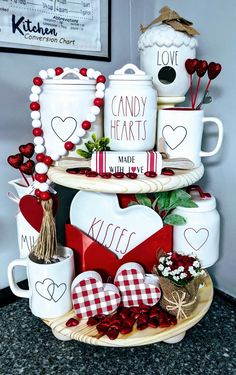 three tiered trays filled with valentine's day decorations and heart shaped mugs