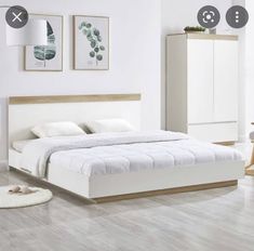 a bedroom with white walls and hardwood floors