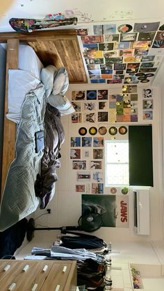 there is a bed with many pictures on the wall above it, and a desk in front of it