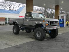 a gray truck parked in front of a gas station