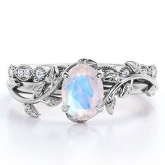 Paint your love story with this Art Deco Filigree Milgrain - 1.5 Carat Egg Cut Blue Moonstone and Moissanite - Beautiful Leaf Bridal Ring Set - 18K White Gold Plating over Silver. Skillfully hand-cut into a nice oval cut by our skilled jewelers, this astounding moonstone wedding band set combines 1.3 carat moonstone engagement ring and .2 carat moissanite engagement ring on solid white gold plating over silver. Distinctive and extraordinary, this silver moonstone ring set is well-suited for thos Moonstone Ring Engagement, Moon Stone Ring, Opal Wedding Ring Set, Rainbow Moonstone Engagement Ring, Opal Wedding Ring, Milgrain Wedding Ring, Opal Wedding Band, Art Deco Filigree, Ring Inspo