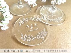 two personalized wine glasses sitting next to each other on a table with white flowers