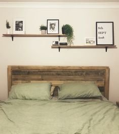 a bed with two shelves above it and pictures on the wall