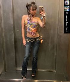 a woman taking a selfie in front of a mirror wearing jeans and a bra