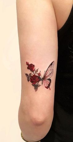 a woman with a tattoo on her arm has a butterfly and roses tattooed on it