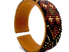 "Made using genuine Guatemalan leather and exquisite glass beads, this cuff bracelet gives off an elegant and luxurious feel. Its unique patterns are brilliantly colored with strong Native American influences. Every piece in our collection is hand stitched with impeccable precision and detail. They are designed to make you feel bold and empowered! Flexible cuff fits all-sized adult wrists Band width measures approximately 3/4\" Handmade in Guatemala *Please note that all of our items are handcra Leather Beaded Bracelets With Round Beads For Gift, Leather Bracelets With Round Beaded Details, Multicolor Beaded Leather Bracelets, Handmade Leather Beaded Bracelets, Brown Beaded Cuff Bracelet Bangle, Brown Beaded Bangle Cuff Bracelet, Brown Beaded Cuff Bracelet, Elegant Leather Beaded Bracelets, Elegant Beaded Leather Bracelets