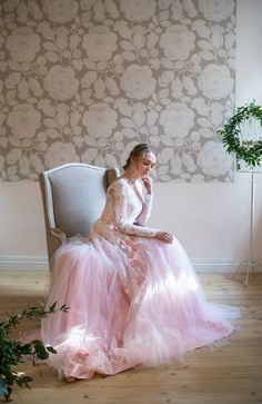 a woman in a pink dress sitting on a chair