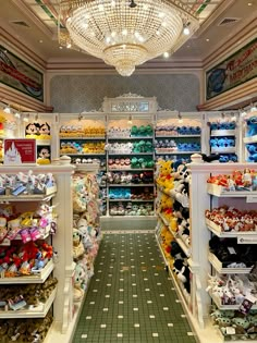 the inside of a toy store with lots of stuffed animals on shelves and in front of a chandelier