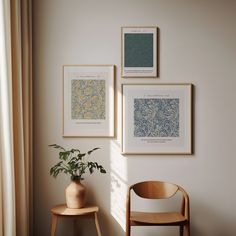 three framed pictures hang on the wall above a wooden chair next to a potted plant