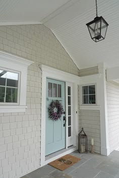 a blue front door with a lantern hanging from the ceiling and a rug on the floor