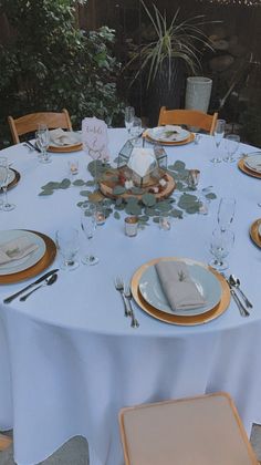 the table is set with plates and silverware for an elegant dinner or special event