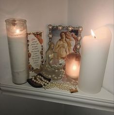 there are candles and pictures on the mantle