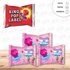 three pink candy bar wrappers sitting on top of a wooden table