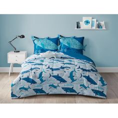 a blue and white bed with shark print on it