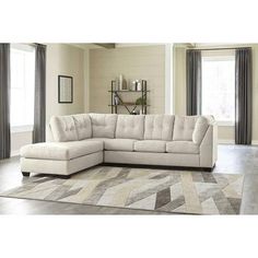 a white sectional couch sitting on top of a rug