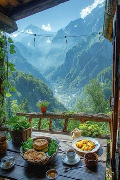 a table topped with plates of food on top of a wooden table next to mountains