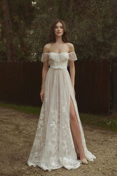 a woman in a white dress standing outside