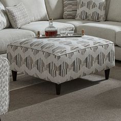 a living room filled with furniture and pillows on top of a carpeted floor next to a window