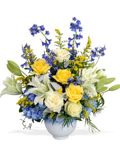 a white vase filled with yellow and blue flowers