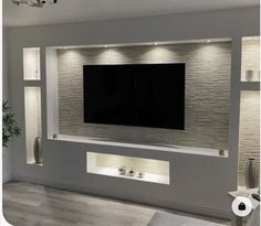 a large flat screen tv mounted to the side of a wall in a living room