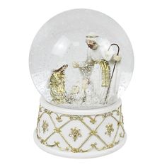 a snow globe with a nativity scene in it and gold trimmings on the base