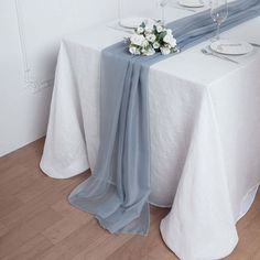 the table is set with white and blue linens