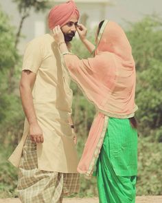 a man in a turban talking on a cell phone next to another man