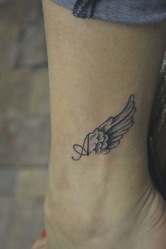 a woman's foot with an angel wing tattoo on the left side of her ankle