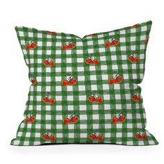 a green and white checkered pillow with cherries on the front, red cherries on