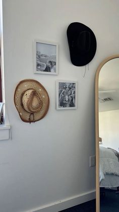 a hat is hanging on the wall next to a mirror and other items in a room