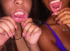 two women with fake teeth and pink lipstick on their mouths are posing for the camera