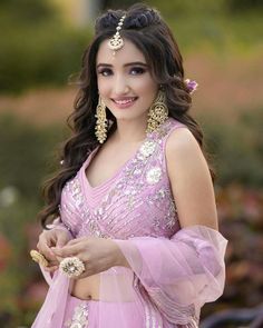 a woman in a pink outfit is posing for the camera