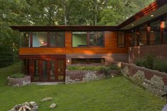 a modern house in the woods with lots of windows and brickwork on the exterior