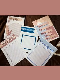 several notebooks and papers on a table with writing paper attached to the top one