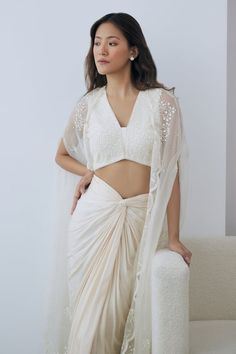 Ivory crepe blouse with floral, beads and sequins embroidery. Comes with a satin knotted draped skirt. - Aza Fashions Elegant Pre-draped Saree With Floral Embroidery, Elegant Floral Embroidered Georgette Choli, White Georgette Saree Dress, White Embellished Silk Sets, Georgette Blouse With Pearl Embroidery For Party, White Georgette Pre-draped Saree With Pearl Embroidery, Elegant Embroidered Top With Traditional Drape For Festive Occasions, Off White Georgette Saree Dress, Elegant Embroidered Sleeveless Pre-draped Saree