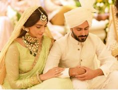 the bride and groom are looking at their cell phones in front of each other while sitting down