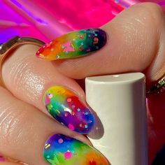 a person with colorful nail polish holding a cup