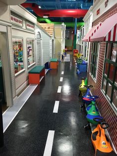 an empty hallway in a toy store with toys on the floor and children's play areas