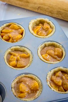 an uncooked muffin tin filled with cupcakes covered in peanut butter