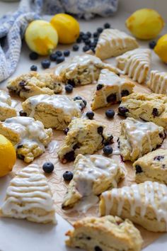 lemon blueberry scones with icing on a plate next to some lemons