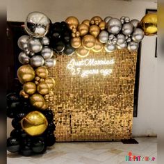 a large balloon display with gold, silver and black balloons