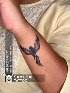 a woman's arm with a tattoo on it that has a bird flying in the air