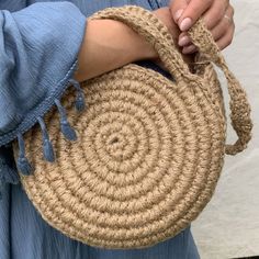 a woman is holding a straw bag in her hands