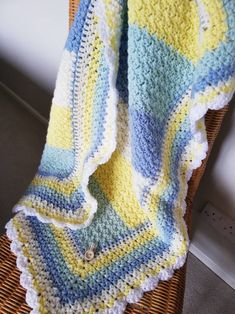 a crocheted blanket sitting on top of a wicker chair